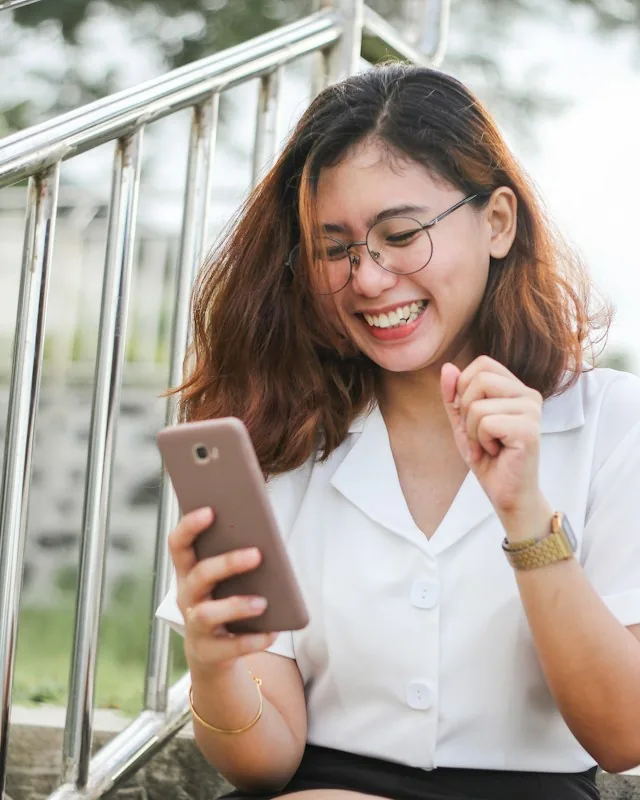 Een blije klant kijkt op haar telefoon